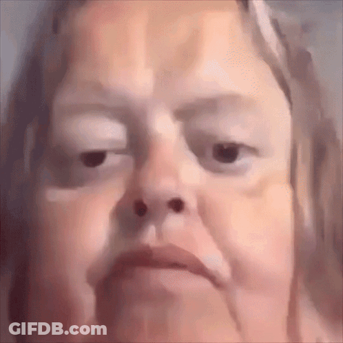 A Close Up Of A Woman 'S Face With A Very Serious Look On Her Face . GIF