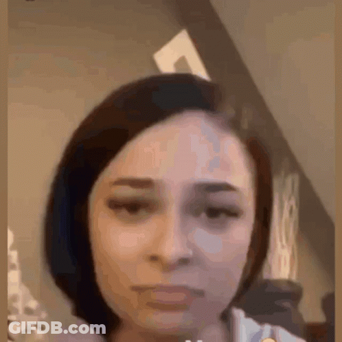 A Close Up Of A Woman 'S Face With A Very Serious Look On Her Face . GIF