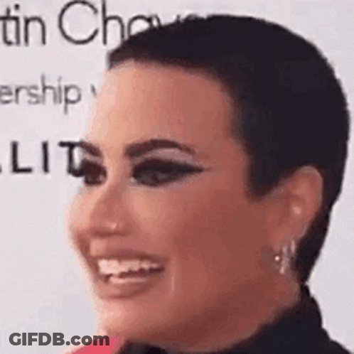 A Close Up Of A Woman 'S Face With A Very Short Haircut . GIF