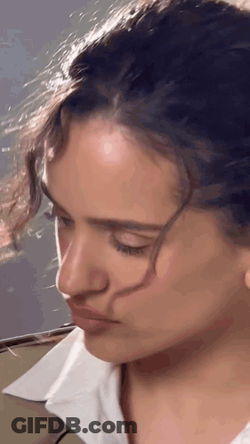 A Close Up Of A Woman 'S Face With A White Shirt GIF