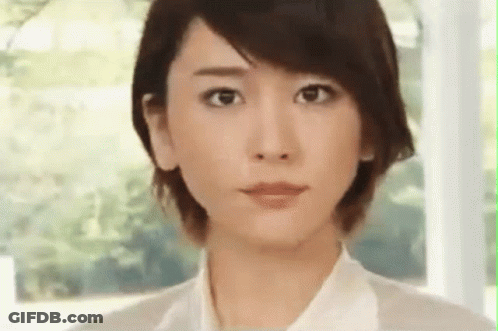 A Close Up Of A Woman 'S Face With A White Shirt On . GIF