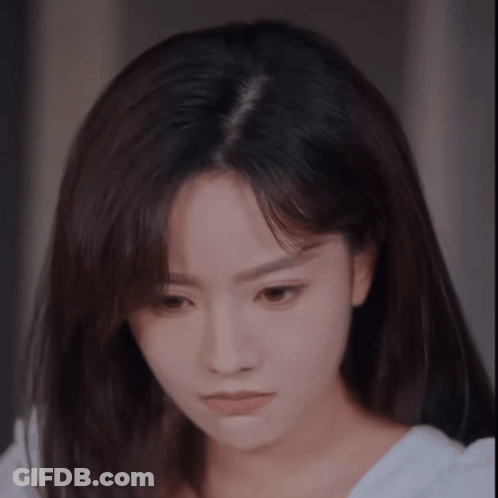 A Close Up Of A Woman 'S Face With A White Shirt On . GIF