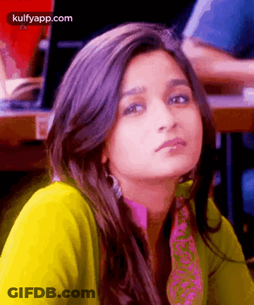 A Close Up Of A Woman 'S Face With A Yellow Shirt And A Pink Scarf . GIF