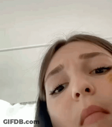 A Close Up Of A Woman 'S Face With A Yellow Sticker On Her Nose . GIF