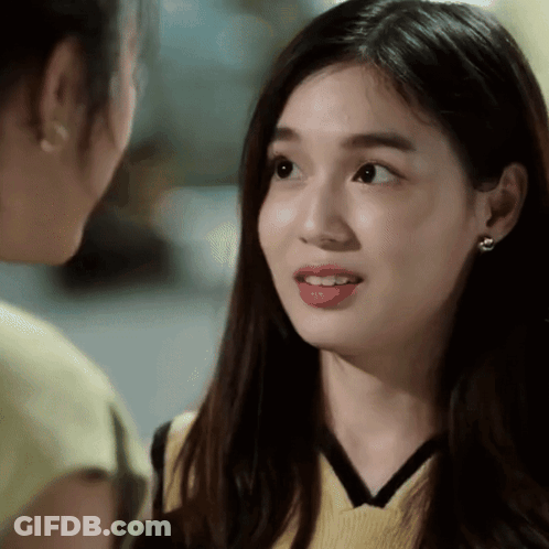 A Close Up Of A Woman 'S Face With A Yellow Top On GIF