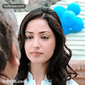 A Close Up Of A Woman 'S Face With Balloons In The Background GIF