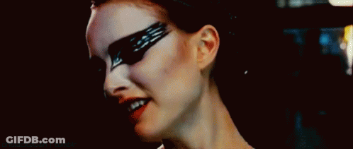 A Close Up Of A Woman 'S Face With Black Feathers Painted On Her Face . GIF