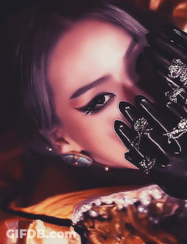 A Close Up Of A Woman 'S Face With Black Gloves On GIF