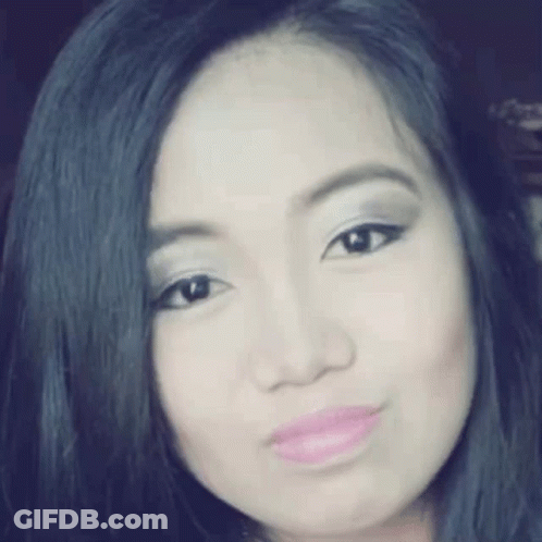 A Close Up Of A Woman 'S Face With Black Hair And Pink Lips . GIF