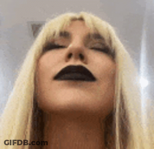 A Close Up Of A Woman 'S Face With Black Lips . GIF