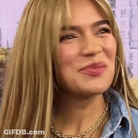 A Close Up Of A Woman 'S Face With Blonde Hair And A Gold Necklace GIF