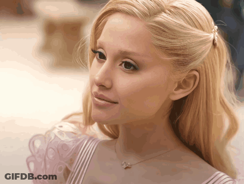 A Close Up Of A Woman 'S Face With Blonde Hair And A Necklace With A Butterfly On It GIF