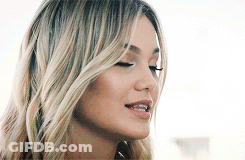 A Close Up Of A Woman 'S Face With Blonde Hair And A Nose Ring . GIF