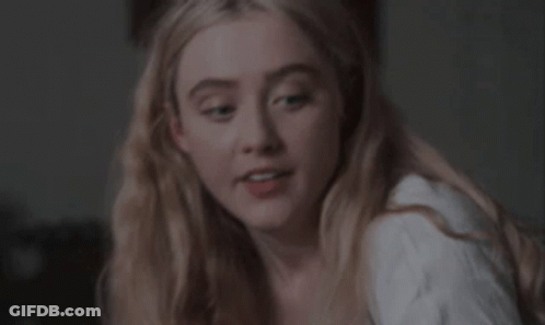 A Close Up Of A Woman 'S Face With Blonde Hair And A White Shirt . GIF