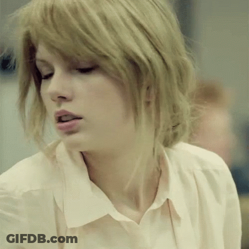 A Close Up Of A Woman 'S Face With Blonde Hair And A White Shirt GIF