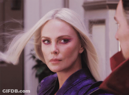 A Close Up Of A Woman 'S Face With Blonde Hair And Purple Eye Shadow GIF
