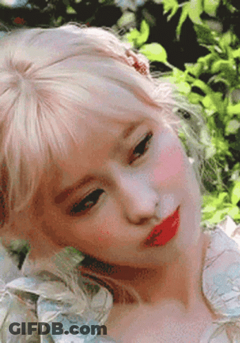 A Close Up Of A Woman 'S Face With Blonde Hair And Red Lips . GIF