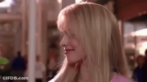 A Close Up Of A Woman 'S Face With Blonde Hair In A Pink Shirt . GIF
