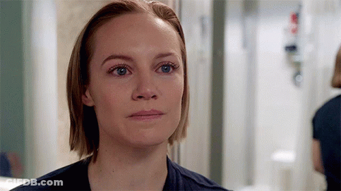 A Close Up Of A Woman 'S Face With Blue Eyes And Short Hair . GIF