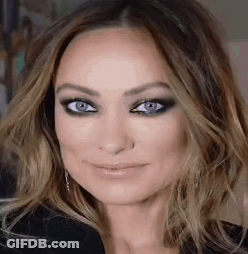 A Close Up Of A Woman 'S Face With Blue Eyes . GIF