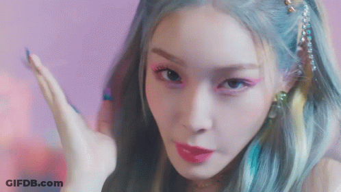 A Close Up Of A Woman 'S Face With Blue Hair And Pink Lipstick . GIF