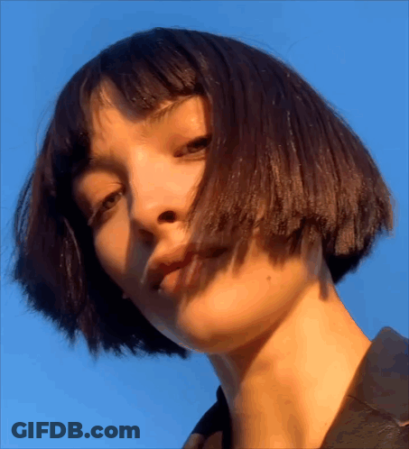 A Close Up Of A Woman 'S Face With Blue Sky In The Background GIF
