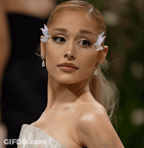 A Close Up Of A Woman 'S Face With Butterfly Earrings GIF