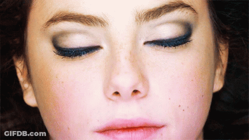 A Close Up Of A Woman 'S Face With Closed Eyes GIF