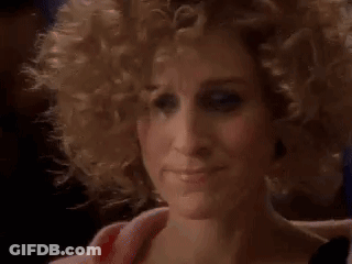A Close Up Of A Woman 'S Face With Curly Blonde Hair . GIF