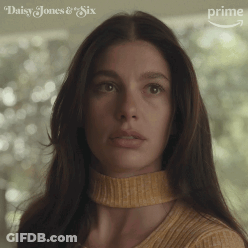 A Close Up Of A Woman 'S Face With Daisy Jones & The Six Written On The Bottom GIF