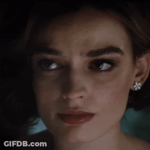 A Close Up Of A Woman 'S Face With Earrings GIF