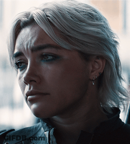 A Close Up Of A Woman 'S Face With Earrings On GIF