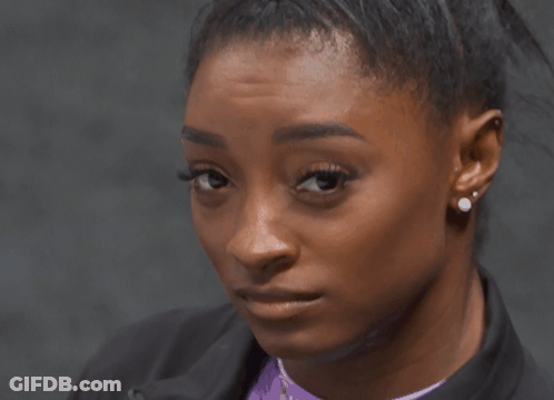 A Close Up Of A Woman 'S Face With Earrings On Her Ears GIF