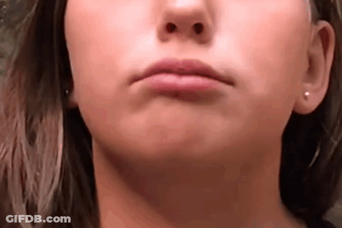 A Close Up Of A Woman 'S Face With Earrings On Her Ears . GIF
