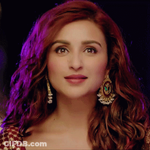 A Close Up Of A Woman 'S Face With Earrings On GIF