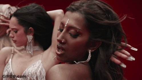 A Close Up Of A Woman 'S Face With Earrings On GIF