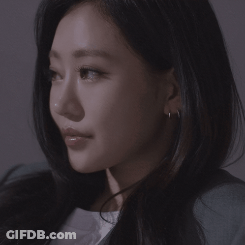 A Close Up Of A Woman 'S Face With Earrings GIF