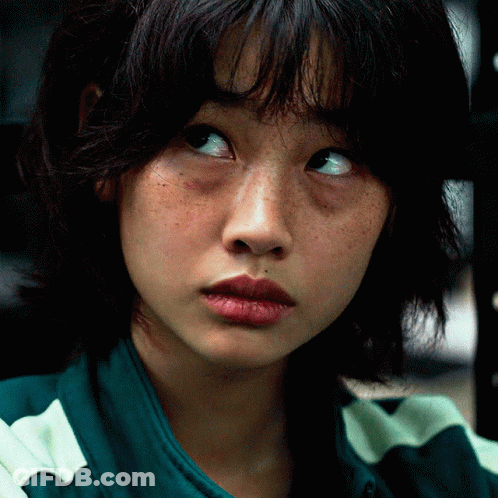 A Close Up Of A Woman 'S Face With Freckles And A Green And White Striped Shirt GIF