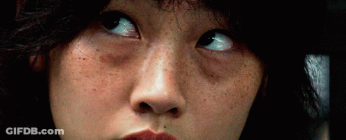 A Close Up Of A Woman 'S Face With Freckles And A Serious Look On Her Face . GIF