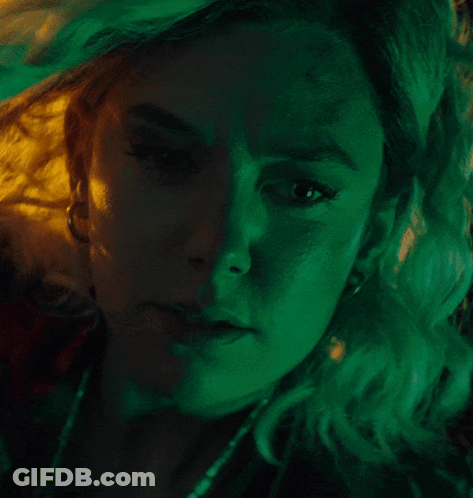 A Close Up Of A Woman 'S Face With Green And Yellow Lights Behind Her GIF