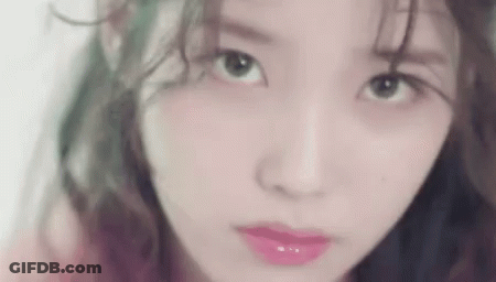 A Close Up Of A Woman 'S Face With Green Hair And Pink Lipstick . GIF