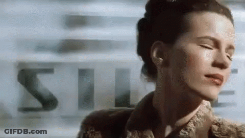 A Close Up Of A Woman 'S Face With Her Eyes Closed And A Blurry Background . GIF