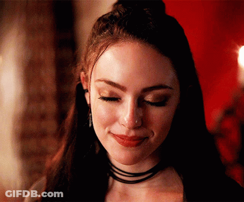 A Close Up Of A Woman 'S Face With Her Eyes Closed And A Choker On Her Neck . GIF