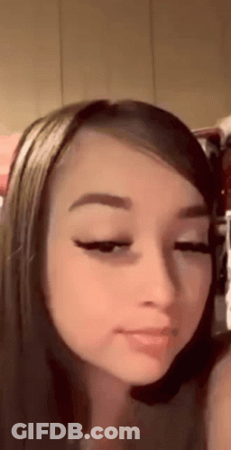 A Close Up Of A Woman 'S Face With Her Eyes Closed And A Piercing In Her Nose . GIF