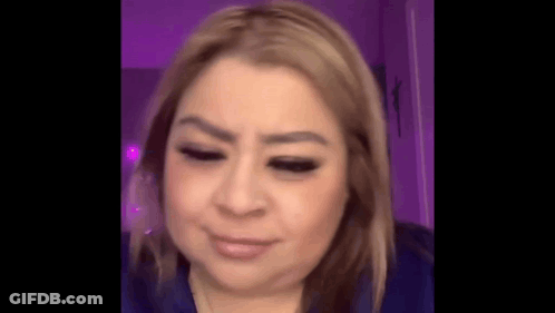 A Close Up Of A Woman 'S Face With Her Eyes Closed And A Purple Background . GIF