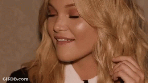 A Close Up Of A Woman 'S Face With Her Eyes Closed And Her Hair Being Touched . GIF