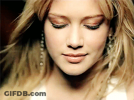 A Close Up Of A Woman 'S Face With Her Eyes Closed And Her Hair Blowing In The Wind GIF