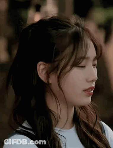 A Close Up Of A Woman 'S Face With Her Eyes Closed And Her Hair In A Half Up Half Down Hairstyle . GIF