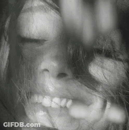 A Close Up Of A Woman 'S Face With Her Eyes Closed And Her Mouth Open . GIF