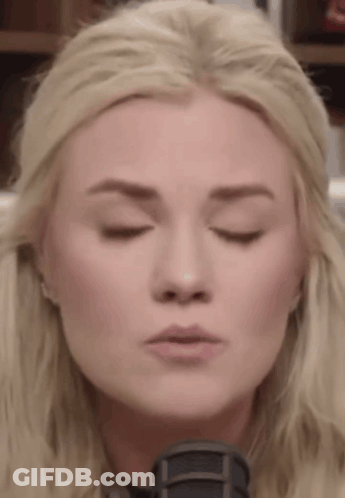 A Close Up Of A Woman 'S Face With Her Eyes Closed And Her Mouth Open . GIF